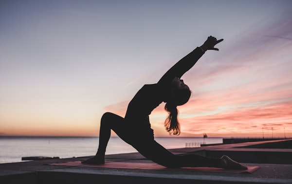 Person holding a yoga pose on a mat